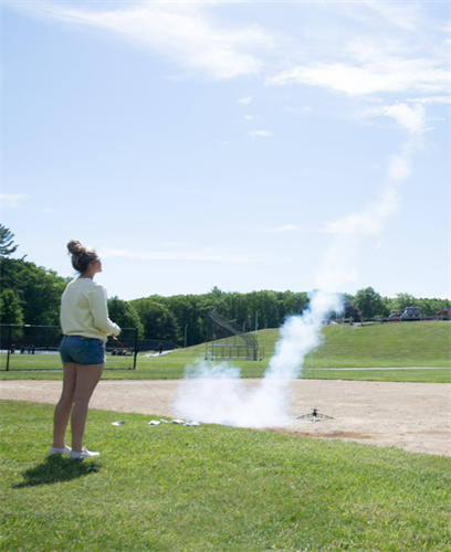 A student watches a rocket trail off